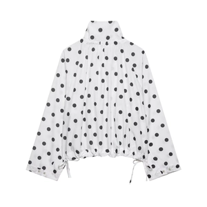 Detail view of long-sleeve polka dot top showing drawstring hem and stand collar design