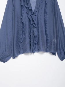 Detail of ruffled V-neck and layered chiffon texture on this elegant blue long sleeve blouse