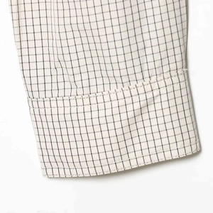 Vue détaillée du motif à carreaux noir et blanc sur le poignet d'une chemise élégante