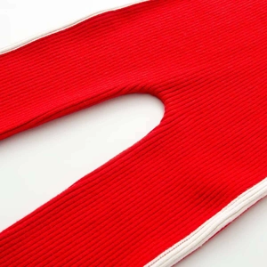 Dettaglio della tuta da sci in maglia a coste rossa con strisce laterali bianche