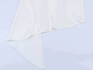 Close-up of asymmetrical hem on a white chiffon blouse with fine edge stitching