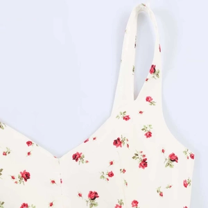 Détail d'une robe d'été blanche à imprimé roses rouges avec une large bretelle élégante