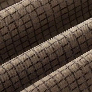 Makroansicht von khakifarbenem Plaid-Wollstoff mit feinem braunem Karomuster-Gewebe