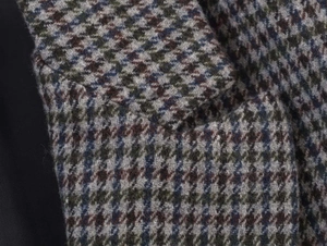 Close-up detail of premium plaid wool fabric texture and sleek black silk lining