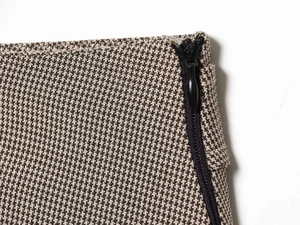 Macro view of plaid houndstooth fabric texture with a black invisible zipper detail