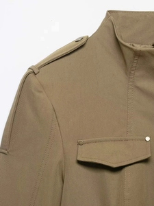 Detailed view of khaki utility jacket featuring epaulettes and silver snap button pockets