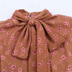 Vintage floral chiffon blouse with neck tie and pink flower pattern on brown fabric