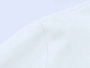 Close-up of needlework seam and fine knit texture on white long-sleeve cotton shirt
