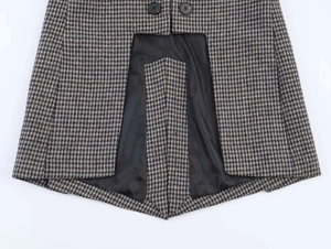 Detail of plaid blazer fabric with black buttons and smooth black satin lining