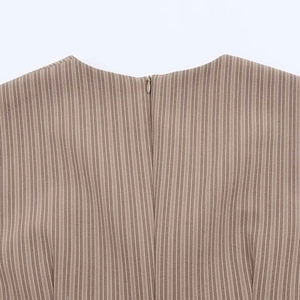 Detail of a brown striped mini dress featuring a concealed back zipper and round neckline