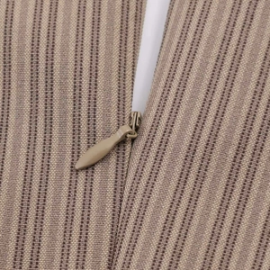 Macro detail of the brown striped fabric and high-quality invisible zipper on the dress