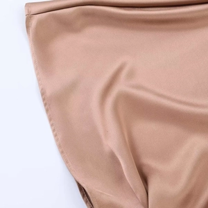 Gros plan du tissu satiné champagne de la robe midi montrant texture et coutures fines