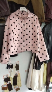 Detail of pink polka dot hooded jacket with white buttons and adjustable drawstring hem
