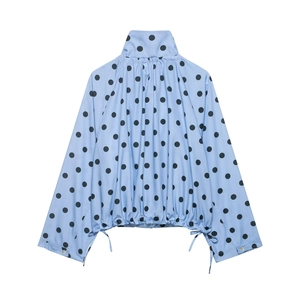Detail of light blue polka dot jacket showing stand collar and adjustable drawstring hem