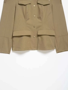 Detail view of khaki utility jacket showing symmetric flap pockets and metal snap buttons