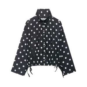 Close-up of black polka dot jacket with high collar, button closure and drawstring hem