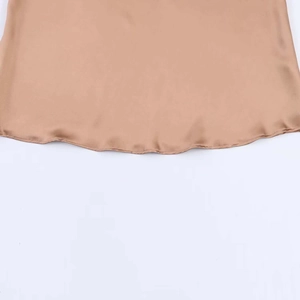 Vue détaillée du tissu en satin champagne montrant la texture lisse et l'ourlet