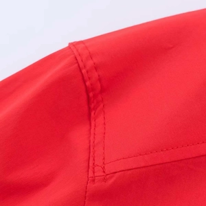 Detailed close-up of double-stitched shoulder seams on a red oversized woven shirt