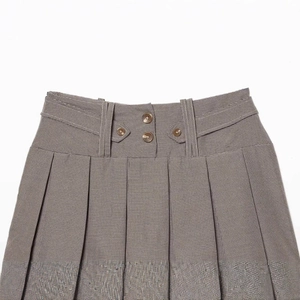 Vintage brown houndstooth pleated mini skirt featuring decorative waist buttons and wide loops