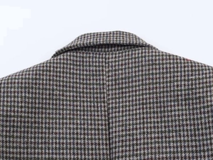 Detail of British style vintage plaid blazer showing lapel and textured wool blend fabric