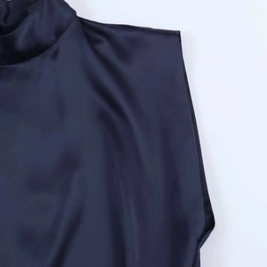 Détail de la robe mini en satin bleu marine à col montant et texture soyeuse lisse