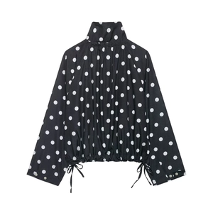 Close-up detail of a polka dot jacket with stand collar and drawstring waist