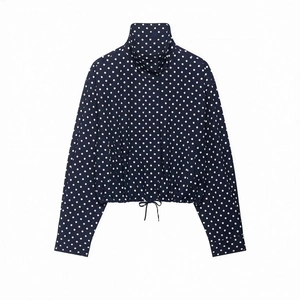 Detailed view of navy blue polka dot jacket with high collar and adjustable drawstring hem