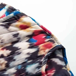 Vue détaillée du tissu matelassé tie-dye avec coutures horizontales et motifs colorés