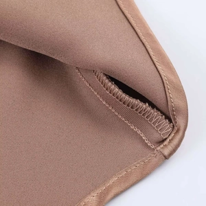 Gros plan détaillé de la couture surjetée sur le tissu satiné marron de haute qualité