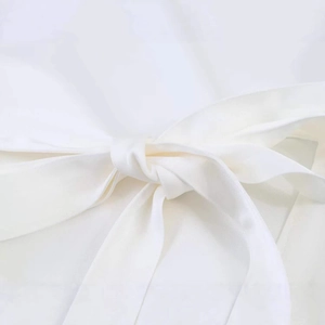 White sleeveless chiffon blouse with elegant back tie knot detail for summer casual style