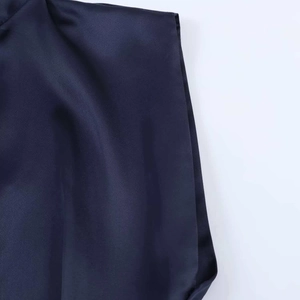 Gros plan sur la texture du tissu en satin bleu foncé et la couture de la robe
