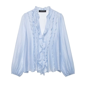 Detailed view of light blue chiffon blouse showing tiered ruffles and V-neckline texture