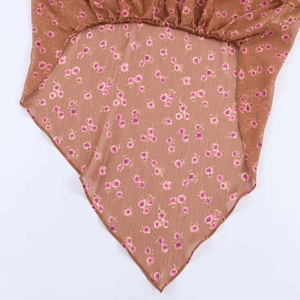 Detail of vintage floral chiffon fabric with delicate pink flowers and sheer texture