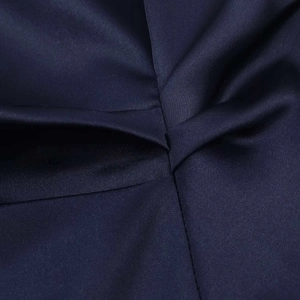 Détail de la robe en satin bleu marine montrant la texture et les fines coutures plissées