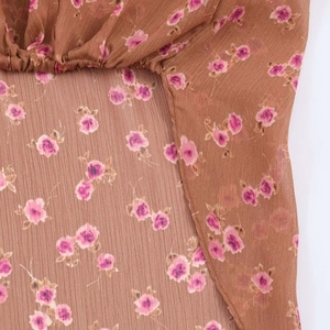 Close-up of floral chiffon fabric with elastic pleats and purple flower print patterns