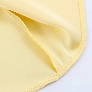 Detail of the high-quality overlock stitching and light yellow satin fabric texture