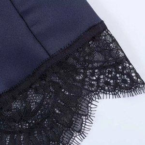 Gros plan du tissu bleu marine avec des détails de patchwork en dentelle noire