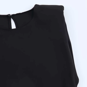 Detail of black dress featuring built-in shoulder pads and single back button closure