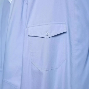 Chemise bleu clair avec épaulettes et une poche avant détaillée dotée d'un bouton discret