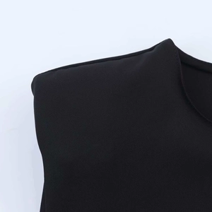 Close-up of structured shoulder pads and smooth knit fabric on black summer mini dress