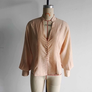 Chemise plissée élégante de couleur pêche avec manches longues et boutons décoratifs
