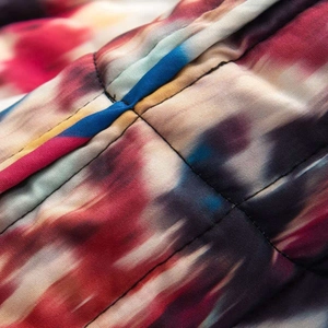 Gros plan détaillé du tissu matelassé avec imprimé tie-dye artistique et coutures