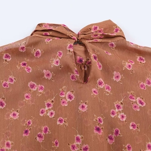 Detail view of floral chiffon blouse with neck bow tie and keyhole cutout design