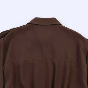 Detail view of the back yoke and epaulet with a metal ring on a dark brown dress