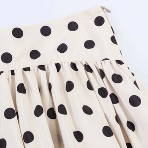 Detailaufnahme des gepunkteten High-Waist-Rocks mit feinen Falten und Reißverschluss