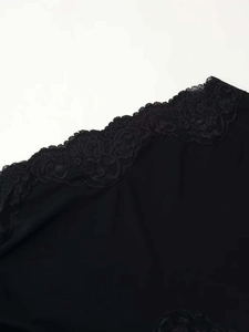 Detail shot of the elegant black floral lace hem on a summer dress dress fabric