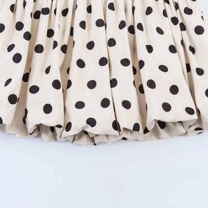 Detailansicht des Retro-Polka-Dot-Rocks mit Faltenwurf und bauschigem Saumdesign in Creme
