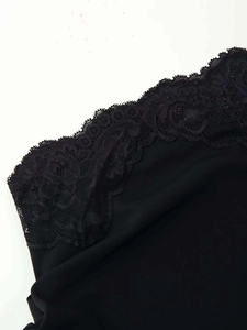 Close-up detail of delicate floral lace trim on the neckline of a black summer dress