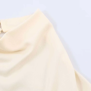 Detailed view of the creamy yellow blouse featuring delicate texture and buttoned neckline