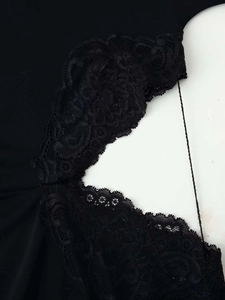 Detailed close-up of intricate black floral lace embroidery and hollow-out design on dress